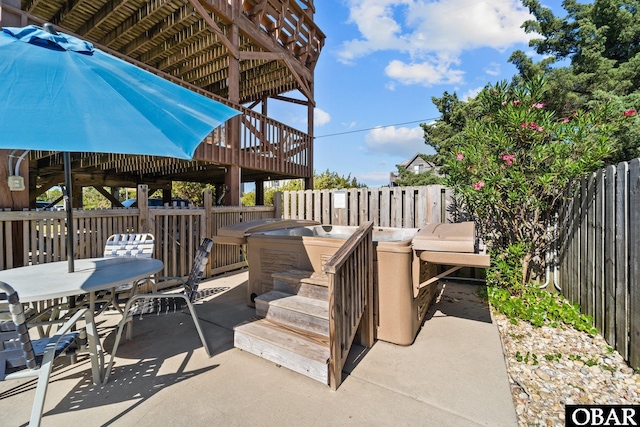 view of patio featuring outdoor dining area, fence, and a deck