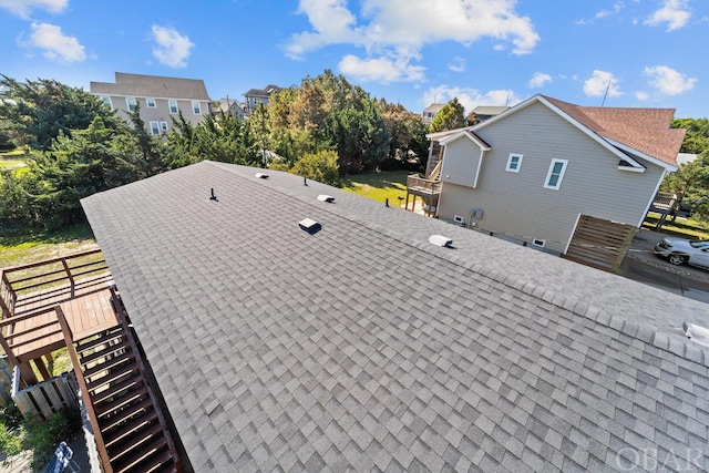 exterior details featuring a residential view and roof with shingles