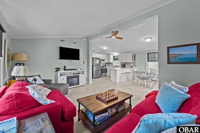 living room with lofted ceiling, visible vents, a ceiling fan, and light tile patterned flooring