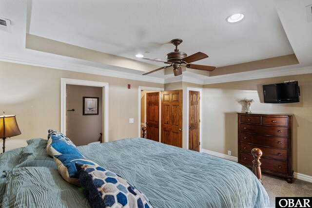 bedroom featuring recessed lighting, carpet floors, baseboards, a tray ceiling, and crown molding