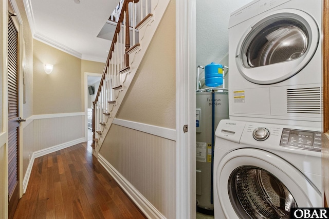 washroom with stacked washer and clothes dryer, crown molding, wainscoting, electric water heater, and wood finished floors