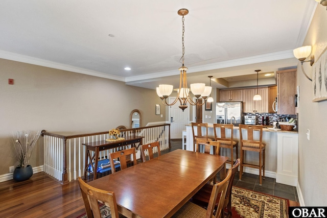 dining area featuring dark wood-style floors, baseboards, a chandelier, and ornamental molding