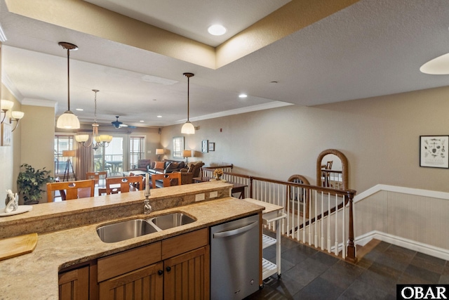 kitchen featuring ornamental molding, open floor plan, hanging light fixtures, stainless steel dishwasher, and a sink