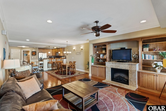 living room featuring crown molding, wood finished floors, and recessed lighting