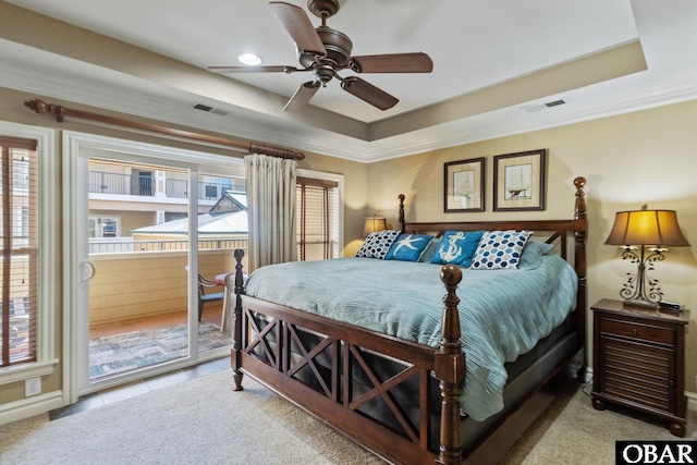 carpeted bedroom featuring a tray ceiling, visible vents, and access to exterior