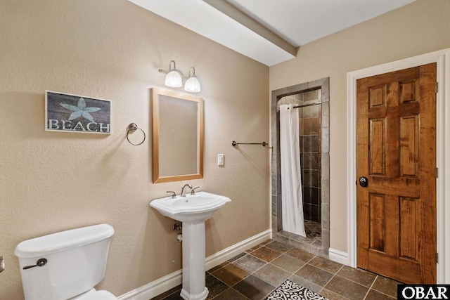 full bathroom featuring a shower stall, toilet, and baseboards