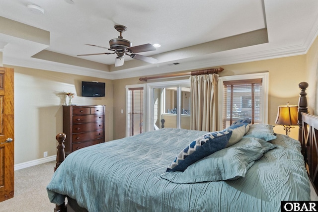 carpeted bedroom featuring a tray ceiling, visible vents, crown molding, and baseboards