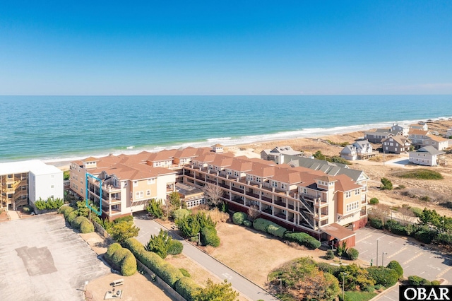 drone / aerial view with a beach view, a residential view, and a water view