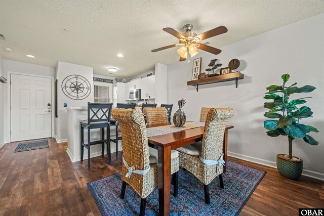 dining space with baseboards, dark wood finished floors, and a textured ceiling