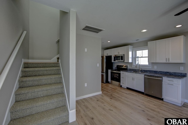 27248 Sand St Lot # 6, Salvo, NC 27972 - kitchen with appliances with stainless steel finishes, light wood finished floors, white cabinetry, recessed lighting, and dark stone counters