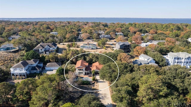 drone / aerial view with a water view, a residential view, and a view of trees