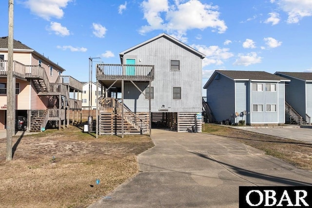 view of front of house featuring stairs, a balcony, and a residential view