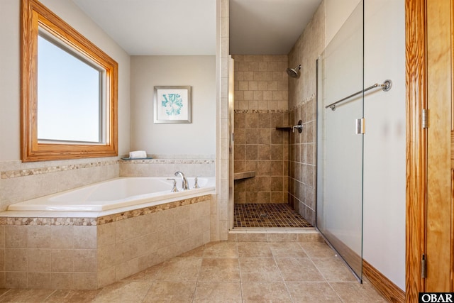 full bath with a stall shower, tile patterned flooring, and a bath