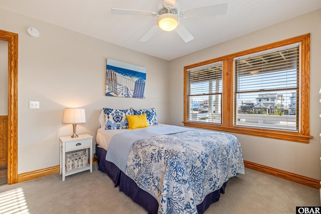 bedroom featuring ceiling fan, baseboards, and light colored carpet