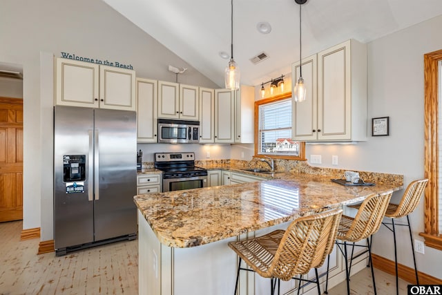 kitchen with stainless steel appliances, a peninsula, a sink, and visible vents