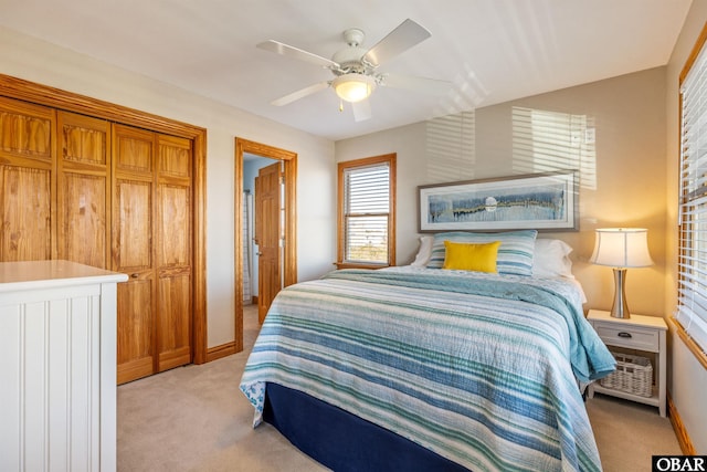 bedroom with light carpet, baseboards, and a ceiling fan