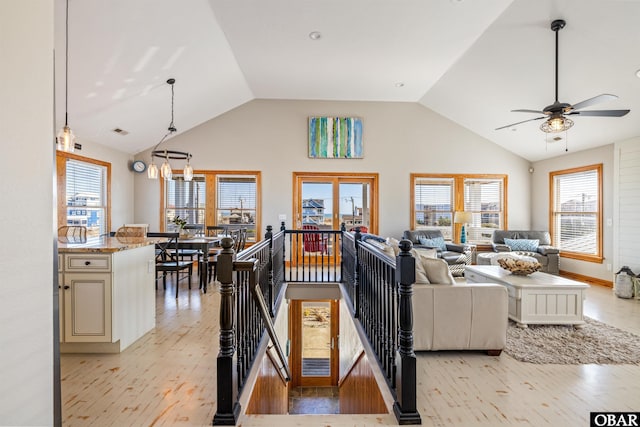 living area with light wood-style floors, a wealth of natural light, and lofted ceiling