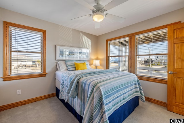 bedroom with baseboards, a ceiling fan, and light colored carpet