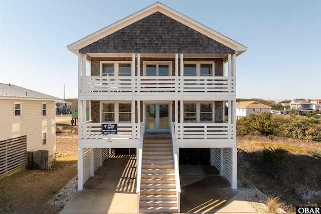 back of property featuring concrete driveway and stairway