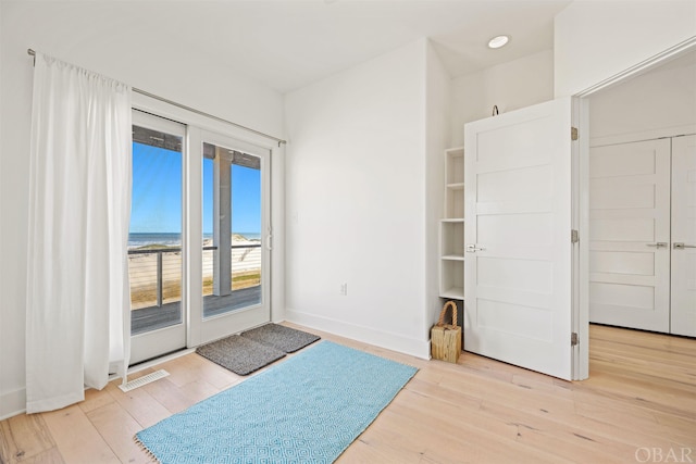 interior space with baseboards, visible vents, and light wood-style floors