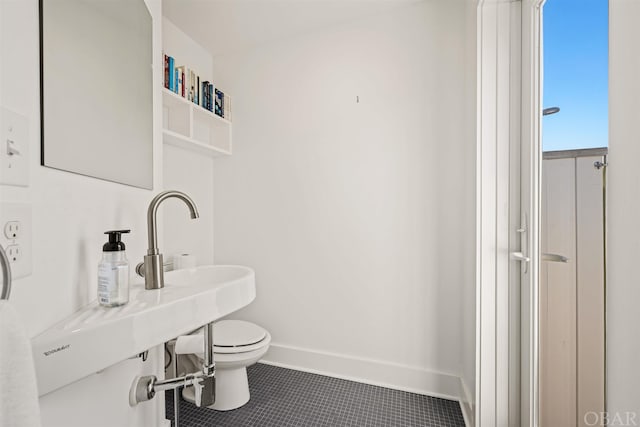 half bath featuring toilet, tile patterned flooring, and baseboards