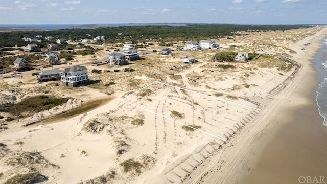 birds eye view of property with a water view and a view of the beach