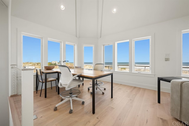 home office featuring recessed lighting, baseboards, a water view, and light wood finished floors