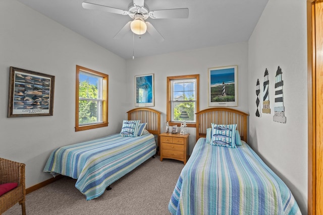 bedroom featuring baseboards, a ceiling fan, multiple windows, and light carpet