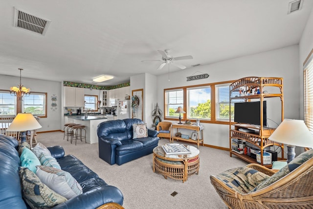 living room with baseboards, ceiling fan with notable chandelier, and visible vents