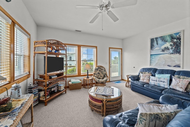 carpeted living room featuring visible vents, ceiling fan, and a wealth of natural light