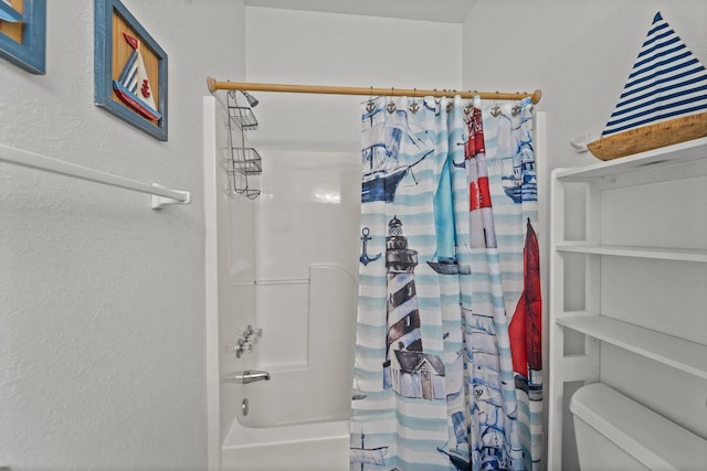 bathroom with shower / bath combo with shower curtain, a textured wall, and toilet