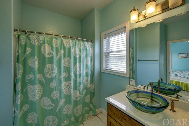 full bathroom featuring connected bathroom, vanity, baseboards, and tile patterned floors
