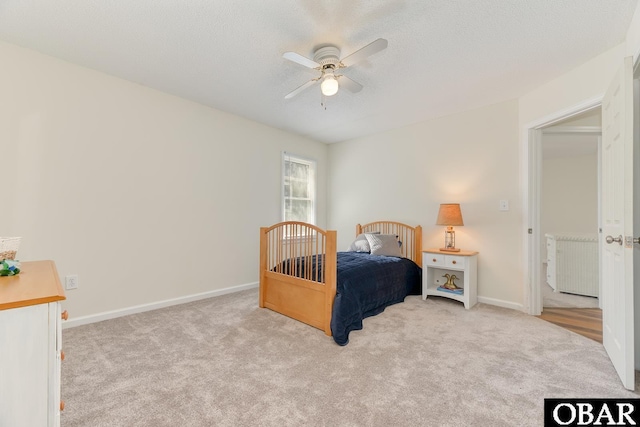 carpeted bedroom with a textured ceiling, a ceiling fan, and baseboards