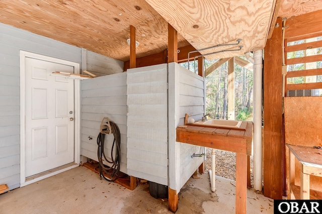 interior space with concrete floors and wooden walls