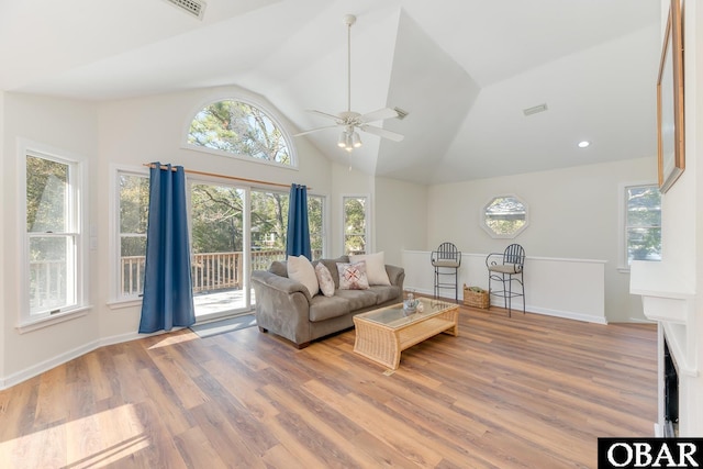 living room with visible vents, baseboards, a ceiling fan, wood finished floors, and high vaulted ceiling