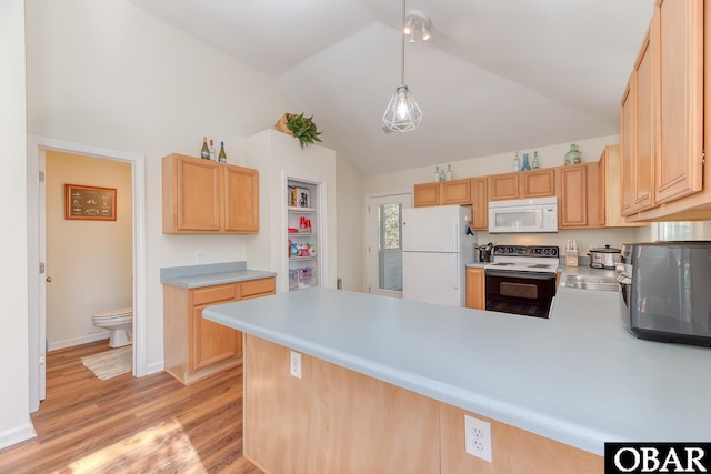 kitchen with white appliances, a peninsula, vaulted ceiling, light countertops, and light wood-style floors