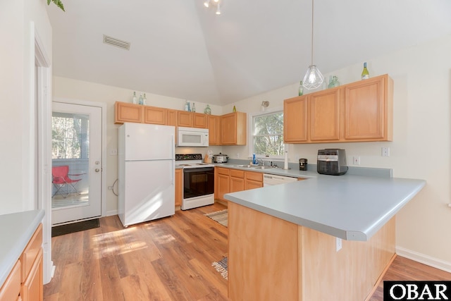 kitchen with white appliances, visible vents, lofted ceiling, a peninsula, and a sink