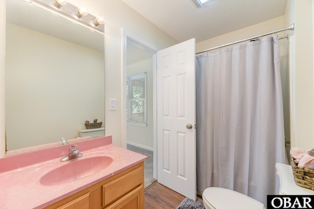 full bath featuring toilet, a shower with curtain, a textured ceiling, and vanity