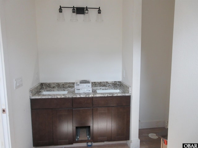 bathroom with a sink, wood finished floors, and double vanity