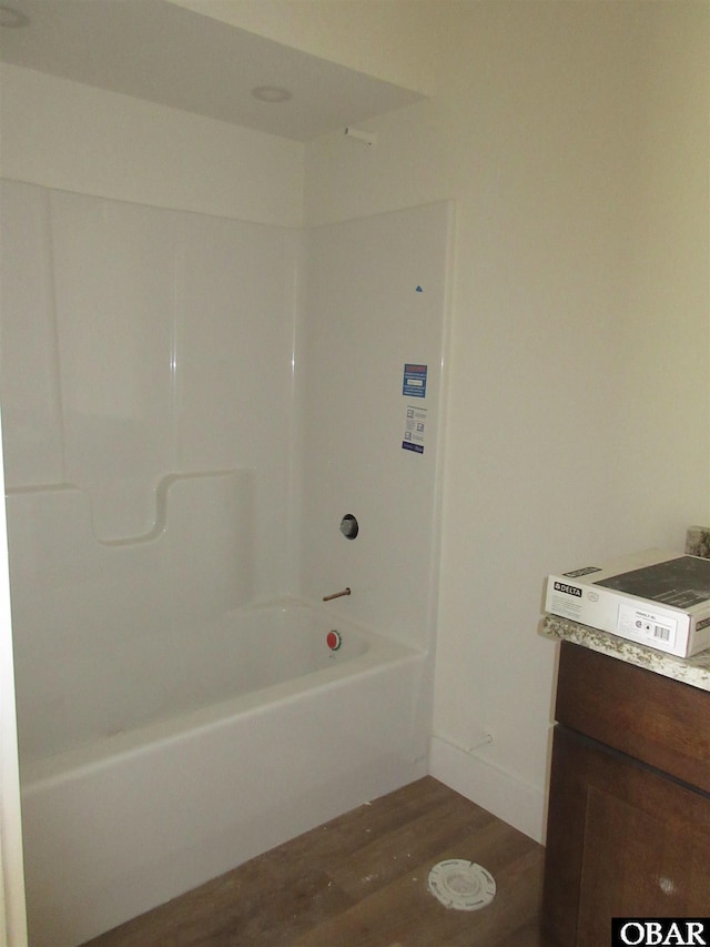 full bath featuring baseboards, vanity,  shower combination, and wood finished floors