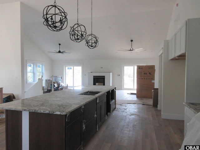 kitchen with a kitchen island with sink, light wood-type flooring, open floor plan, and a ceiling fan