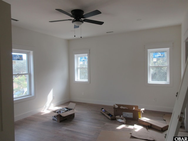 spare room featuring visible vents, wood finished floors, and baseboards