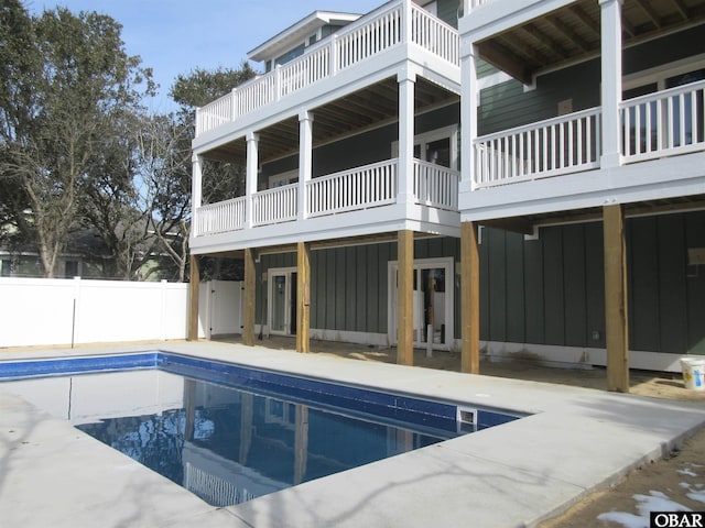 exterior space featuring a fenced in pool, board and batten siding, and fence