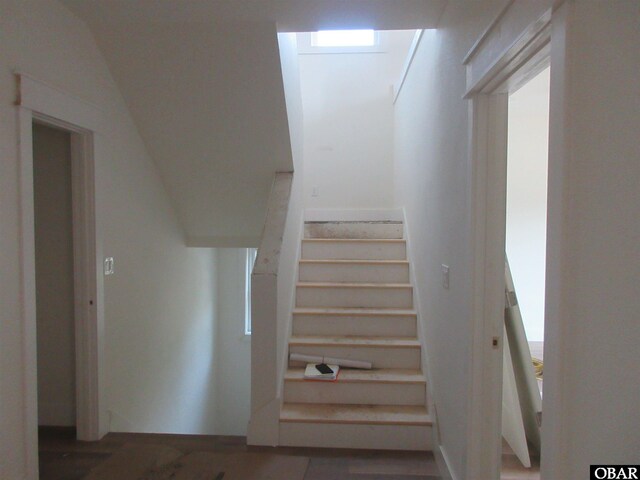 stairs featuring visible vents, baseboards, a healthy amount of sunlight, and wood finished floors