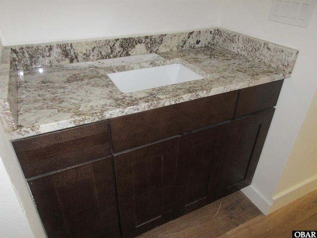 bathroom with wood finished floors, baseboards, and a sink