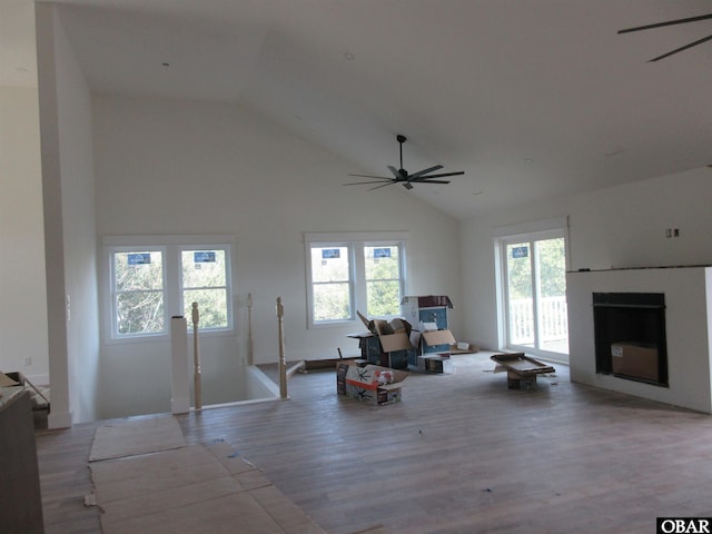 living area with a wealth of natural light, a fireplace, and a ceiling fan