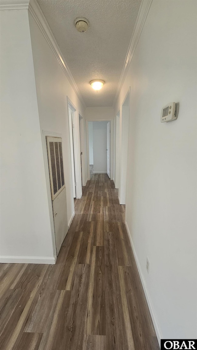 hall featuring crown molding, baseboards, dark wood-style flooring, and a textured ceiling