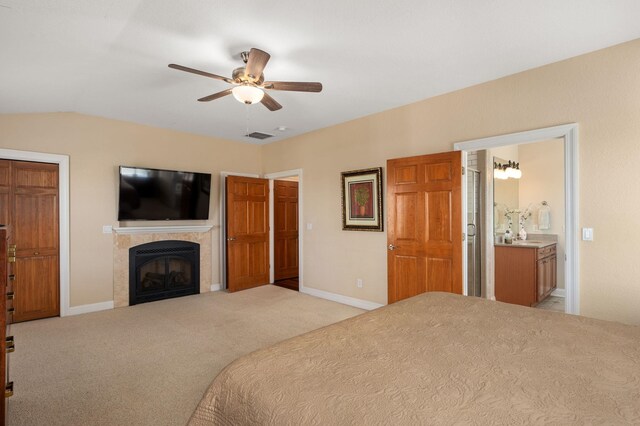 bedroom with carpet, a tiled fireplace, lofted ceiling, and baseboards