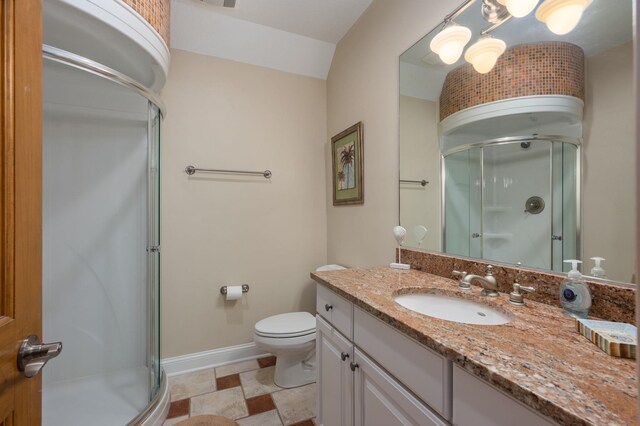 full bathroom with toilet, a stall shower, baseboards, and vanity