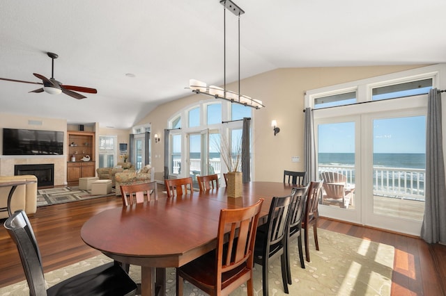 151 Buffell Head Rd Lot 179, Duck, NC 27949 - dining area with vaulted ceiling, wood finished floors, a ceiling fan, a fireplace, and a water view